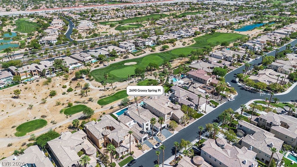 2690 Grassy Spring Place, Las Vegas, NV 89135 An aerial perspective showcases a quiet desert neighborhood nestled along the manicured fairways of a golf course.