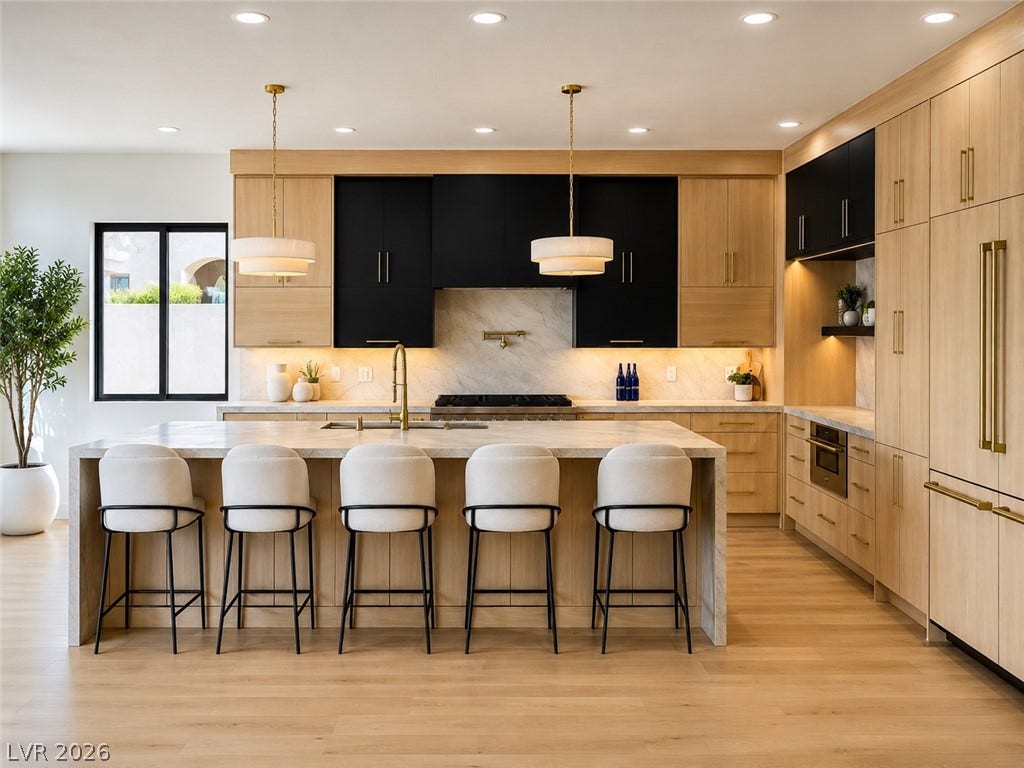 2690 Grassy Spring Place, Las Vegas, NV 89135 Custom cabinetry and marble countertops anchor this refined modern workspace with wood flooring.