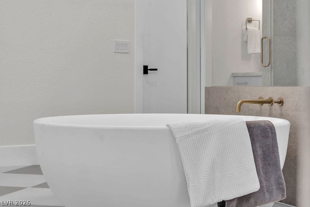 2690 Grassy Spring Place, Las Vegas, NV 89135 A deep soaking tub pairs elegantly with modern wall-mounted brass fixtures.