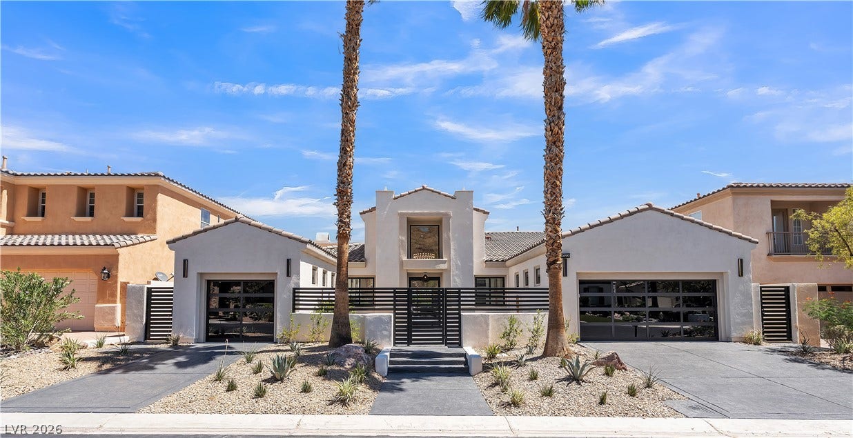 2690 Grassy Spring Place, Las Vegas, NV 89135 Desert landscaping and towering palms frame the modern stucco exterior and contemporary glass garage doors.