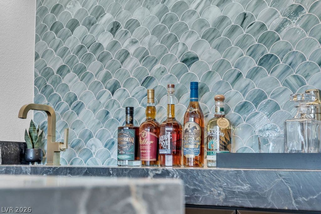 2690 Grassy Spring Place, Las Vegas, NV 89135 A stylish wet bar features a scalloped tile backsplash and premium stone countertops.