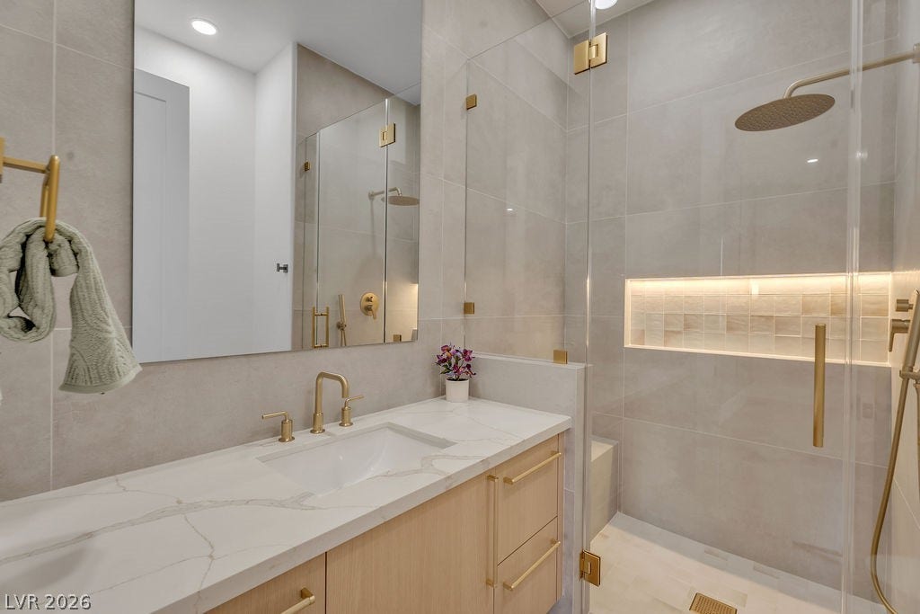 2690 Grassy Spring Place, Las Vegas, NV 89135 Sophisticated stone countertops and elegant gold hardware elevate this contemporary bathroom design.