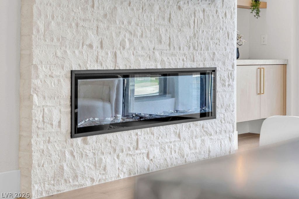 2690 Grassy Spring Place, Las Vegas, NV 89135 A contemporary double-sided glass fireplace sits embedded in a textured stone accent wall.