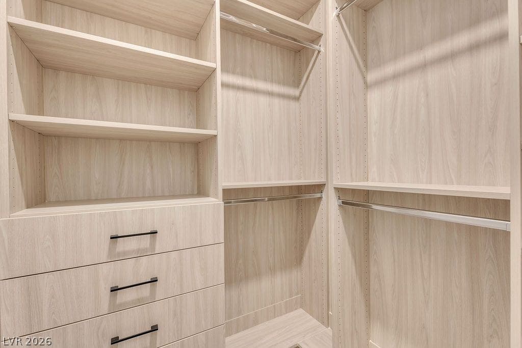 2690 Grassy Spring Place, Las Vegas, NV 89135 Custom wood shelving and integrated dresser drawers maximize storage in this walk-in closet.