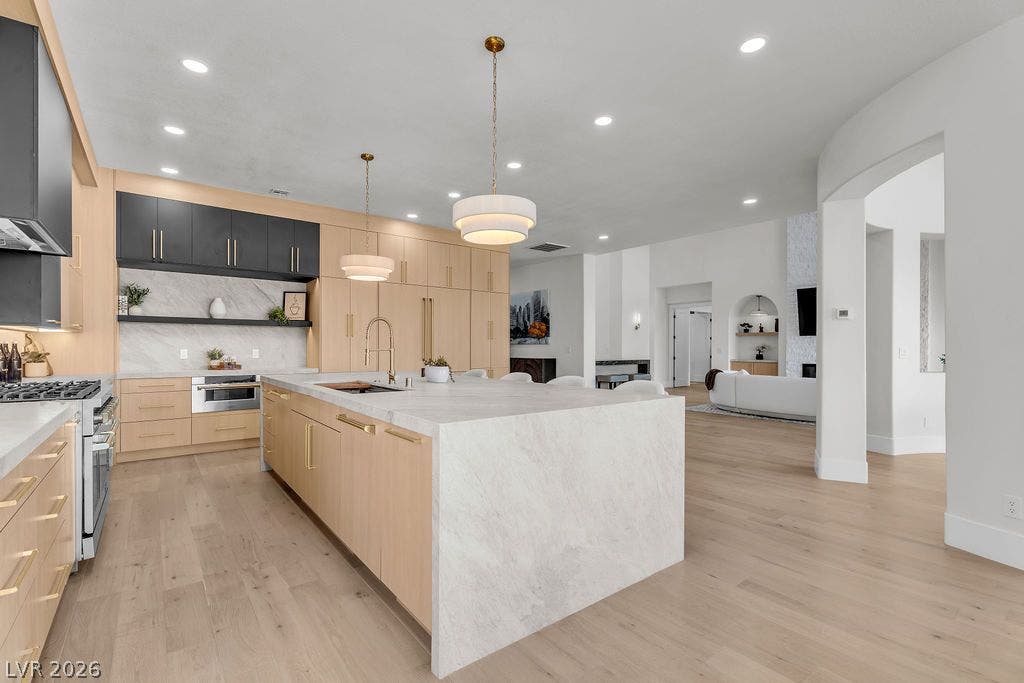2690 Grassy Spring Place, Las Vegas, NV 89135 Smooth wood floors flow throughout this kitchen centered around a waterfall marble island.