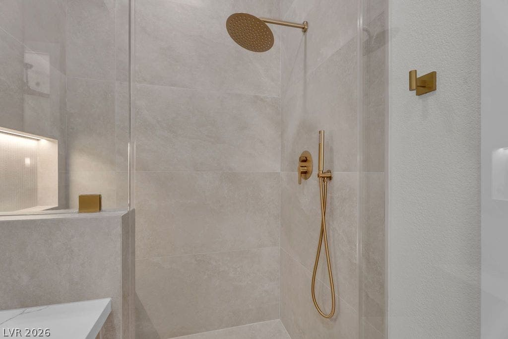 2690 Grassy Spring Place, Las Vegas, NV 89135 Gold-toned fixtures complement the large-format tile walls in this modern walk-in shower.
