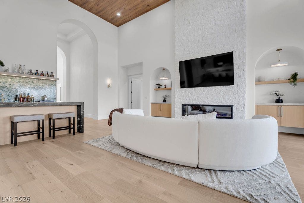 2690 Grassy Spring Place, Las Vegas, NV 89135 High wood-clad ceilings and a floor-to-ceiling textured fireplace highlight this open concept living area.