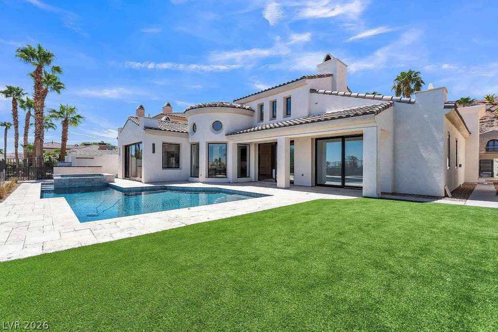 2690 Grassy Spring Place, Las Vegas, NV 89135 An inviting backyard oasis showcases a stone-paved patio alongside a pristine swimming pool.