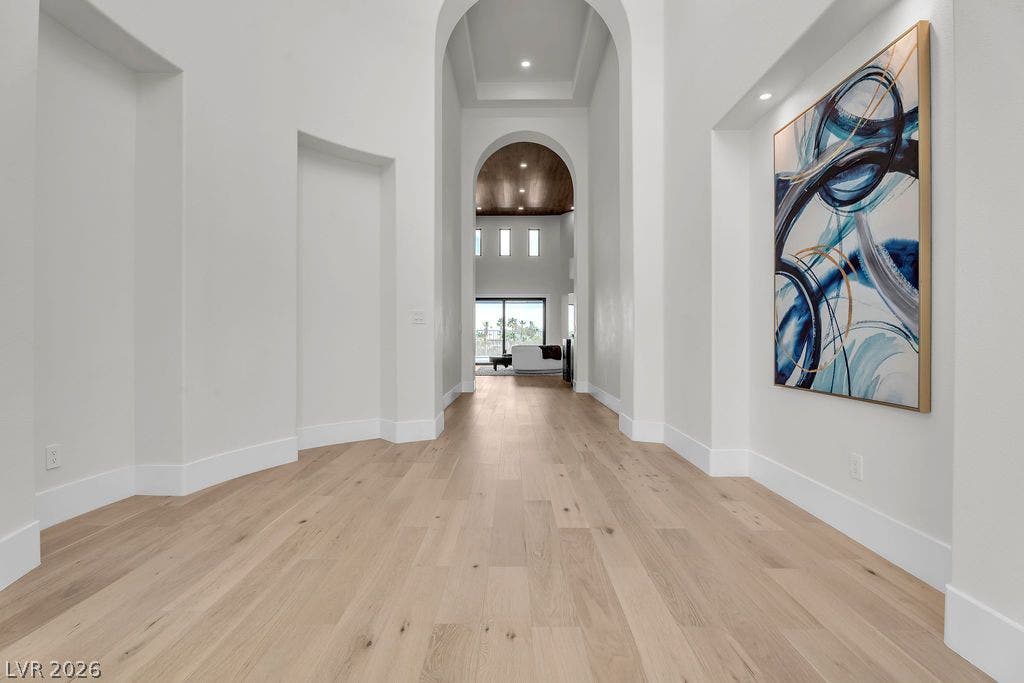 2690 Grassy Spring Place, Las Vegas, NV 89135 Dramatic arched gallery transitions seamlessly to a soaring foyer with light wood flooring.