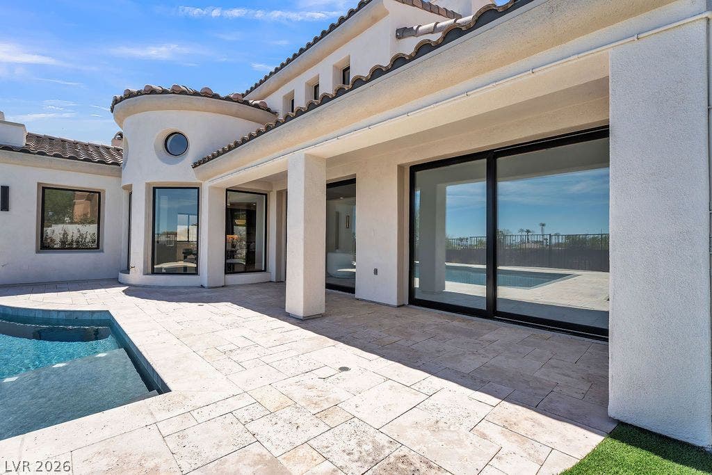 2690 Grassy Spring Place, Las Vegas, NV 89135 Large sliding glass doors open directly from the stucco exterior to the tiled pool deck.