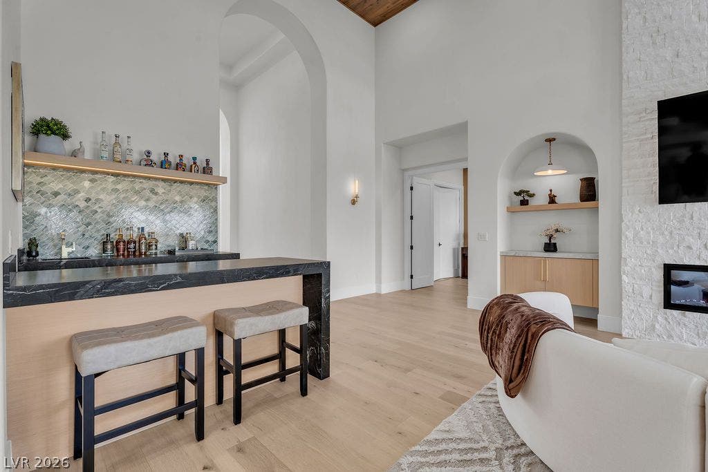 2690 Grassy Spring Place, Las Vegas, NV 89135 High ceilings and light wood floors frame an elegant wet bar and stone fireplace.