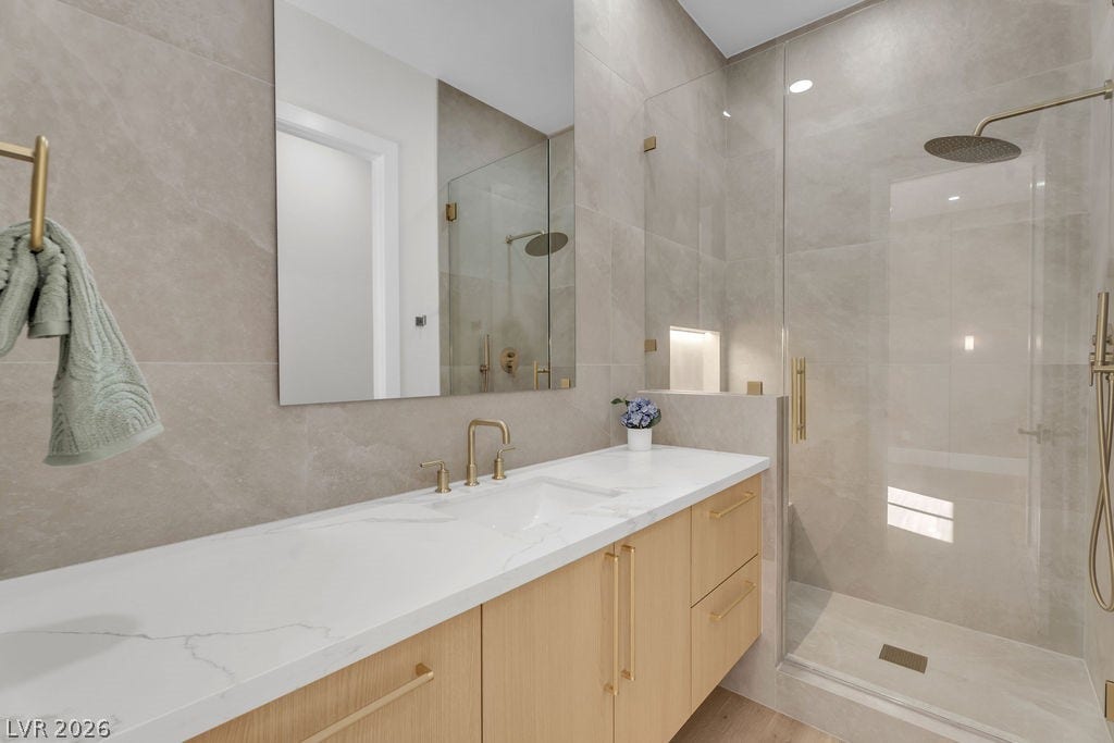 2690 Grassy Spring Place, Las Vegas, NV 89135 Clean lines and stone-tiled walls create a tranquil ambiance in this modern bath.