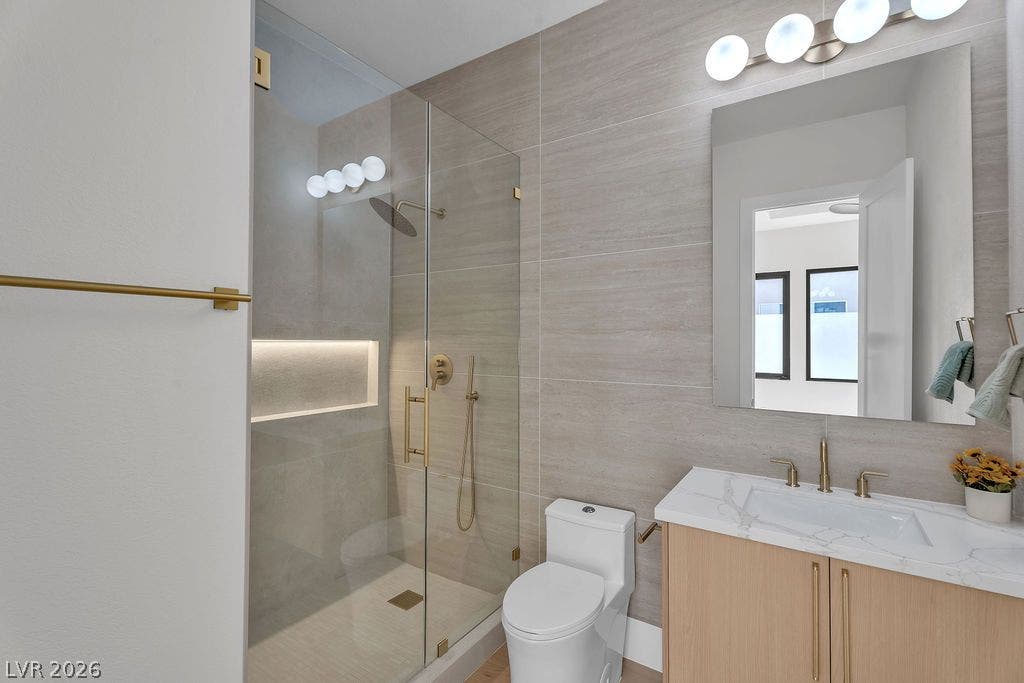 2690 Grassy Spring Place, Las Vegas, NV 89135 Modern stone tile walls and glass-enclosed walk-in shower elevate this contemporary bathroom design.