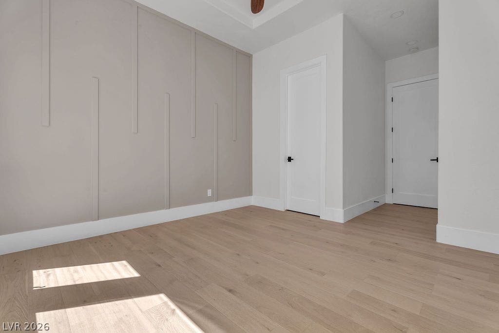 2690 Grassy Spring Place, Las Vegas, NV 89135 Fine wood flooring and geometric wall paneling define this modern, light-filled interior space.
