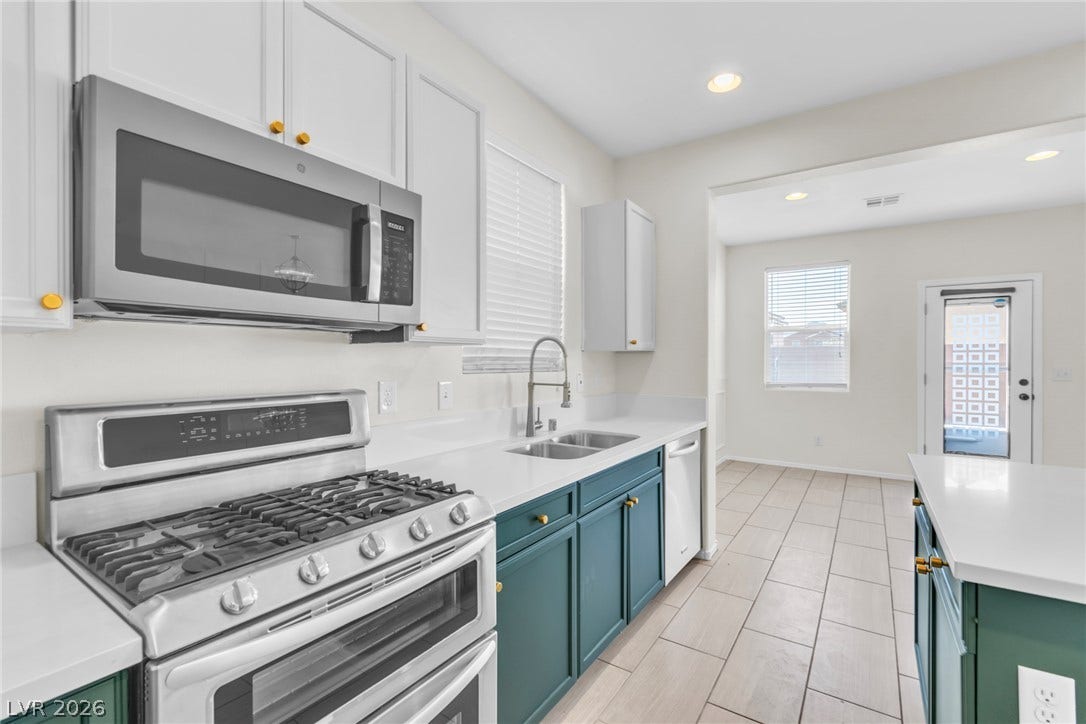 Crisp white upper cabinets and clean stone counters frame the functional workspace.