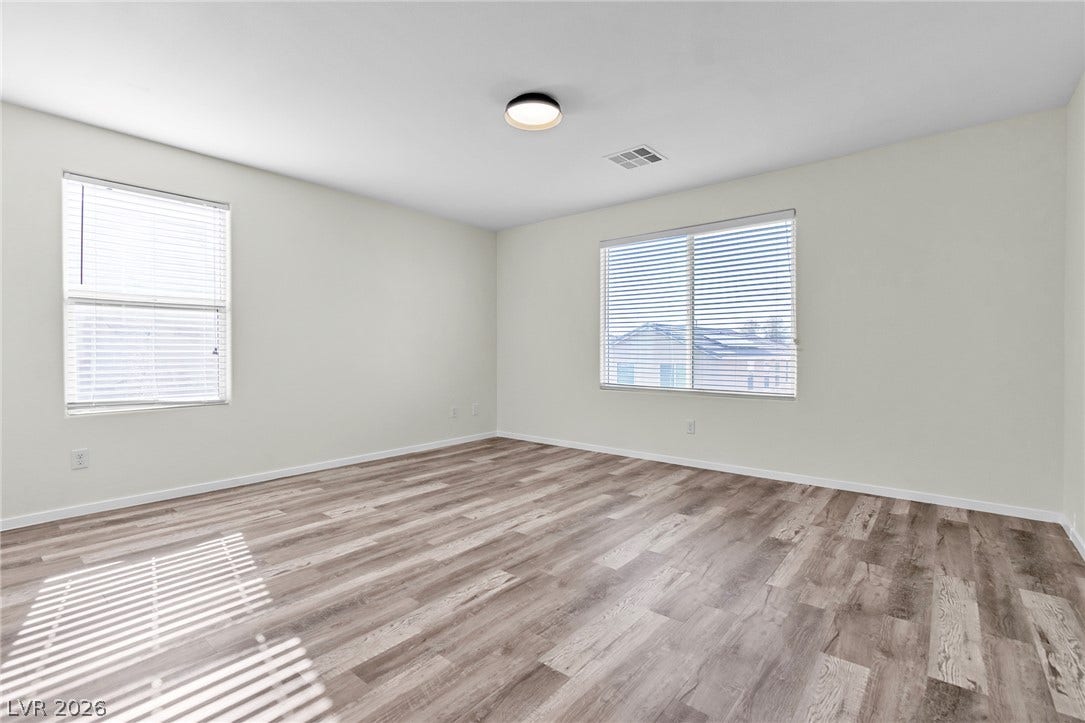 Smooth wood-look flooring and dual windows define this versatile secondary room.