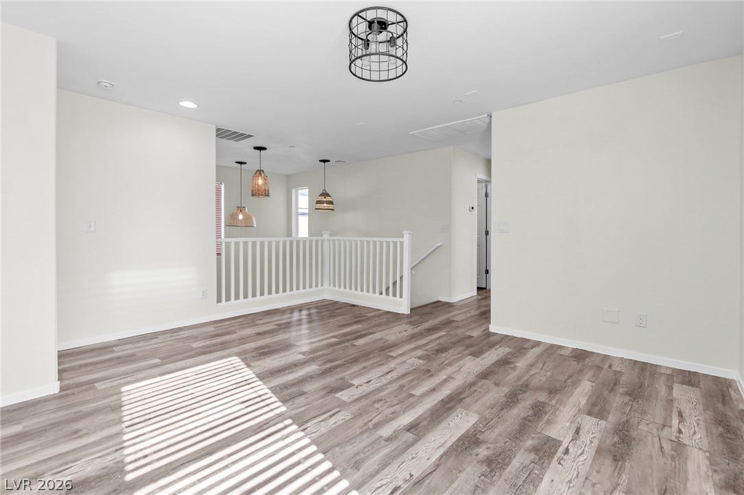 Clean lines and smooth wood floors define this open upper-level landing space.