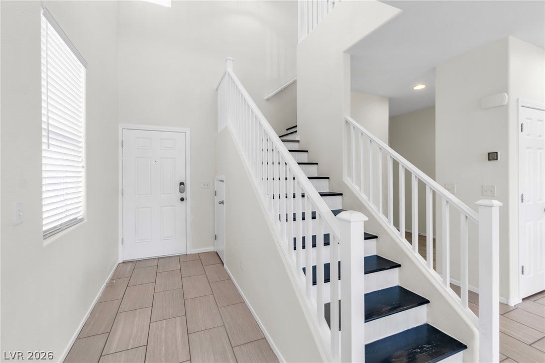 Tiled flooring and a striking open staircase define this light-filled entry space.