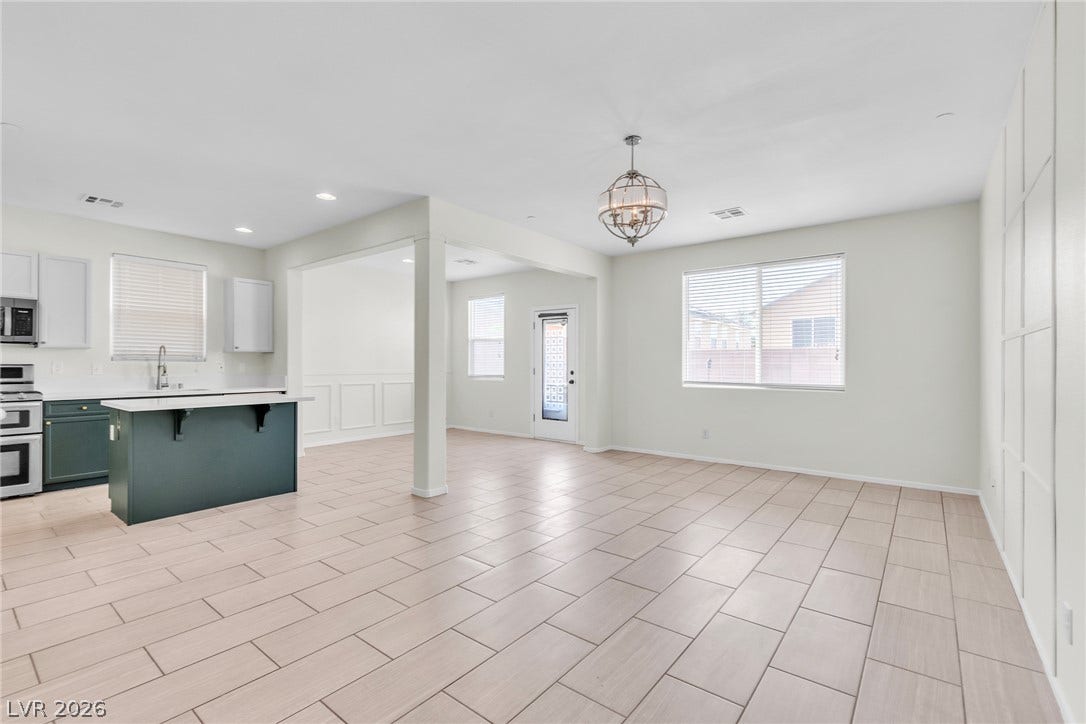 An open-concept living area seamlessly connects to the kitchen over durable tile flooring.