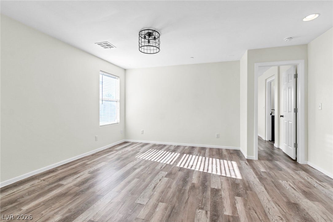 Smooth wood-look flooring and clean white walls create a versatile canvas ready for any setup.