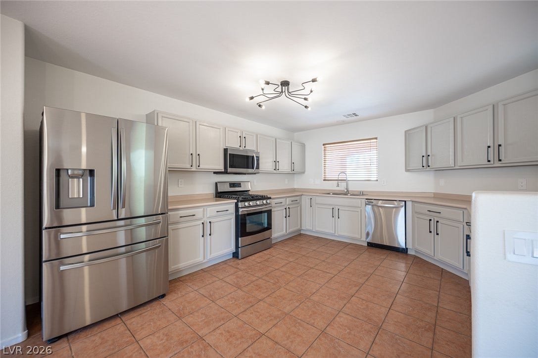 6133 Crystal Talon Street, Las Vegas, NV 89130 Ample cabinetry and tile flooring define this functional kitchen workspace.