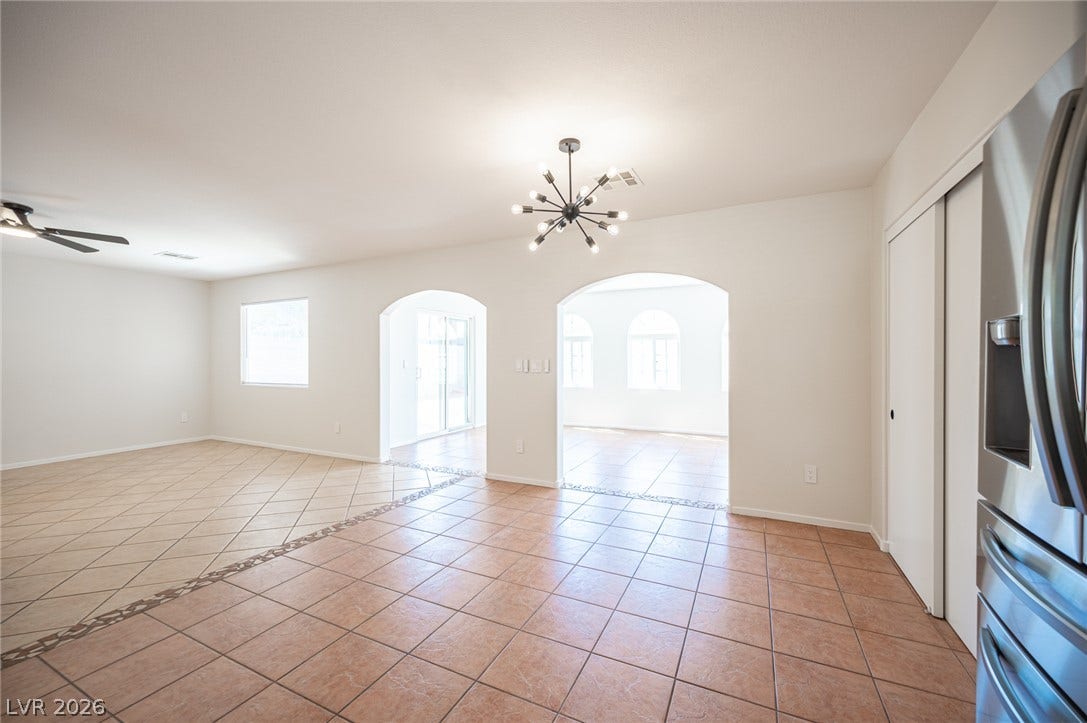 6133 Crystal Talon Street, Las Vegas, NV 89130 Arched doorways connect the open tile living areas under a modern light fixture.