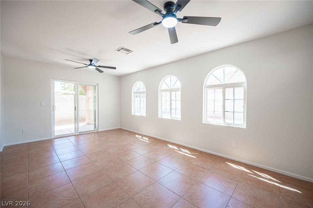 6133 Crystal Talon Street, Las Vegas, NV 89130 Tiled flooring and arched windows define this light-filled room opening to the outdoors.