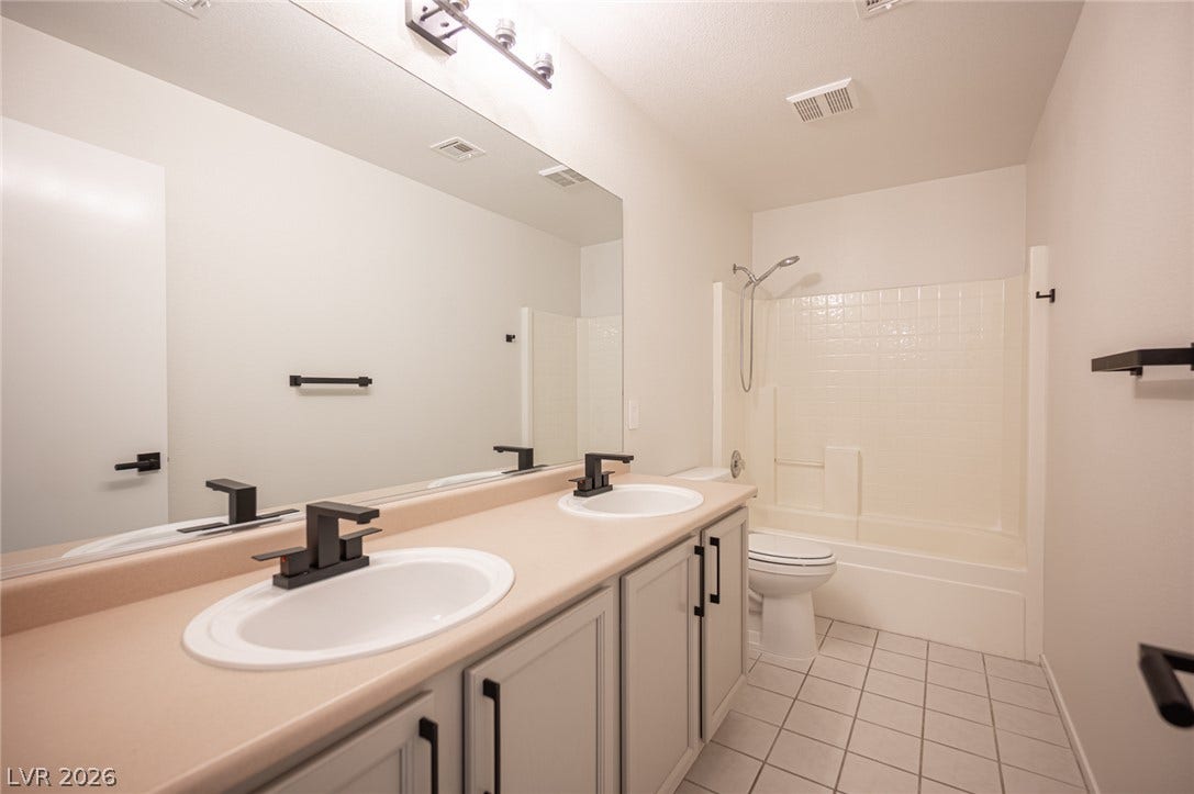 6133 Crystal Talon Street, Las Vegas, NV 89130 Double vanity sinks and tiled floors anchor this clean, functional upstairs bathroom.