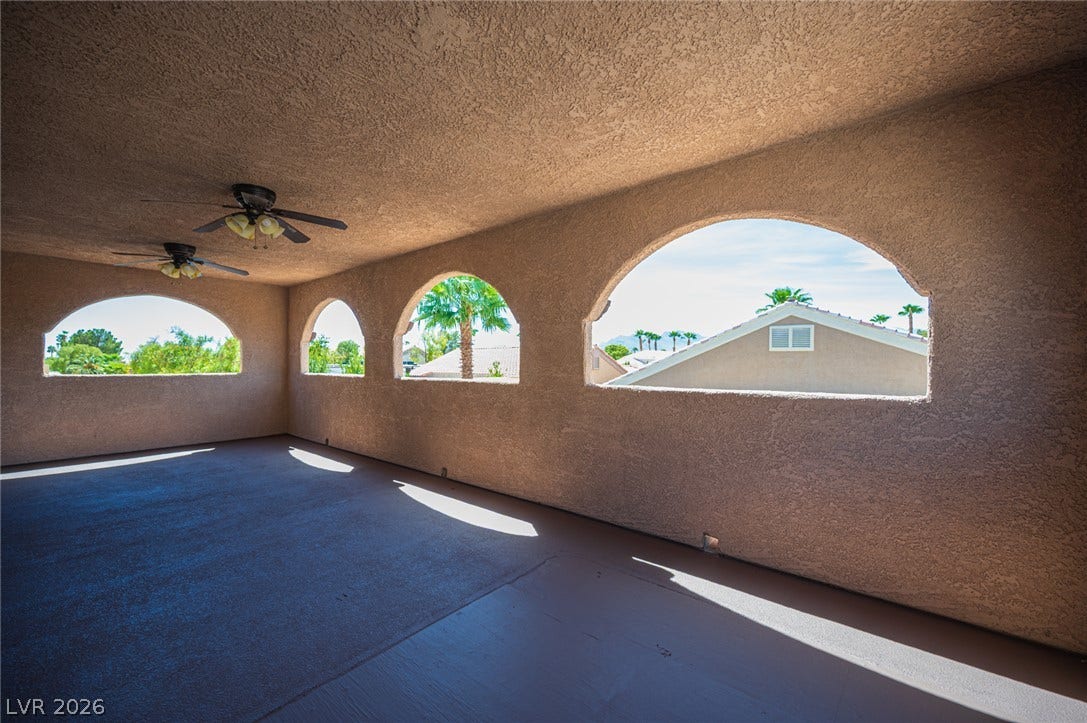 6133 Crystal Talon Street, Las Vegas, NV 89130 Arched openings frame neighborhood views from a spacious, covered outdoor terrace.