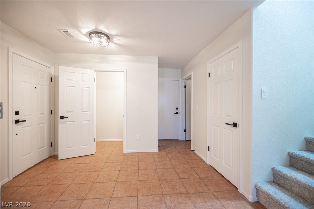 6133 Crystal Talon Street, Las Vegas, NV 89130 Tiled flooring and neutral walls define this functional entryway next to a carpeted staircase.