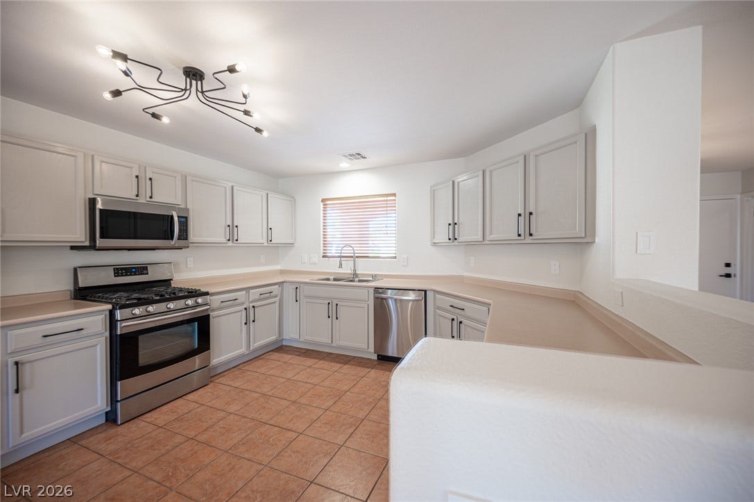 6133 Crystal Talon Street, Las Vegas, NV 89130 Ample cabinetry and tile flooring define this spacious kitchen workspace.