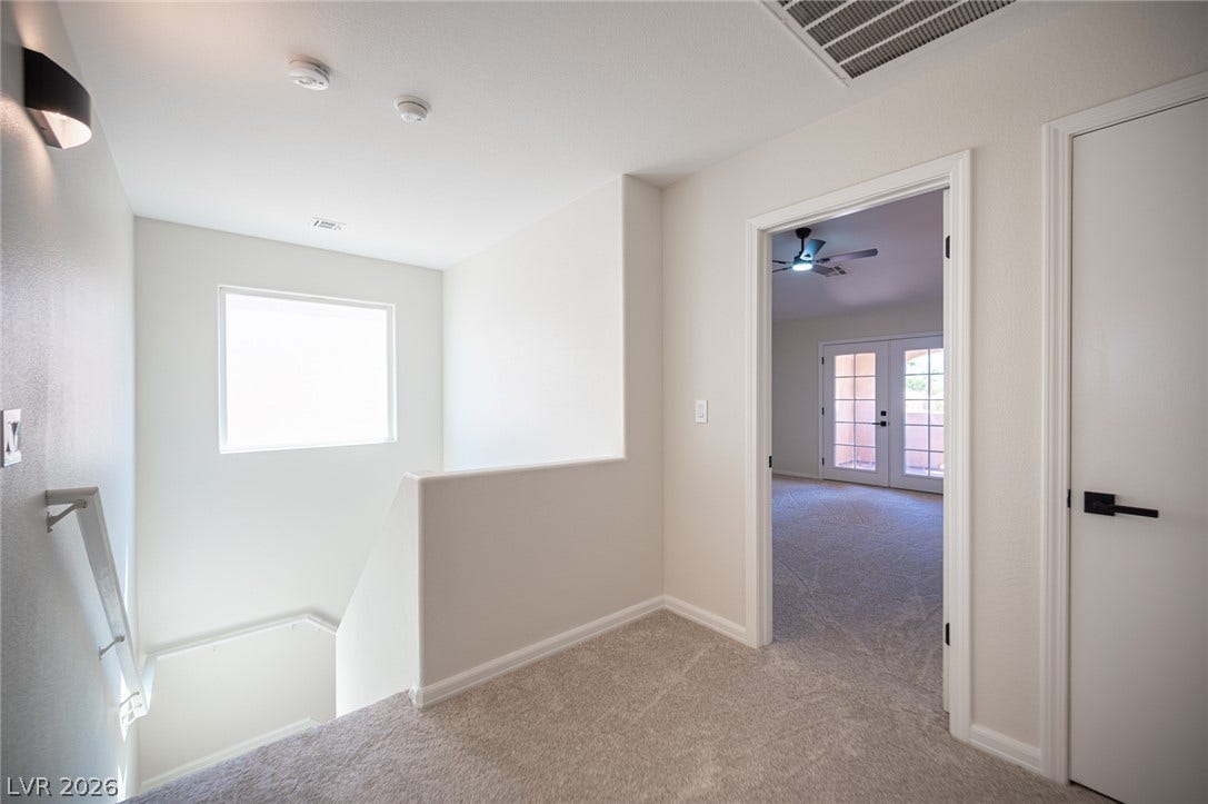6133 Crystal Talon Street, Las Vegas, NV 89130 An upper landing features plush carpeting and smooth walls leading to bedrooms and stairs.