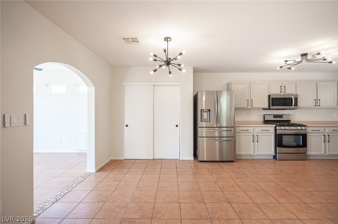 6133 Crystal Talon Street, Las Vegas, NV 89130 An arched doorway connects the tile-floored kitchen and adjacent dining area.