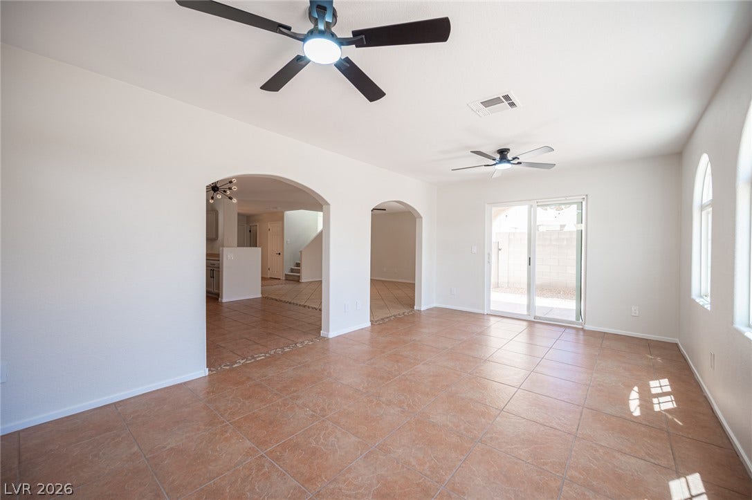 6133 Crystal Talon Street, Las Vegas, NV 89130 Tiled flooring and broad arched doorways define this spacious, light-filled main living area.
