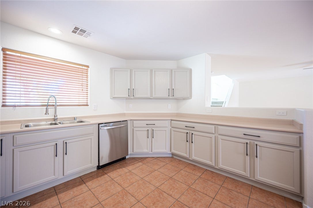 6133 Crystal Talon Street, Las Vegas, NV 89130 Functional cabinetry wraps around this kitchen featuring tile flooring and integrated preparation spaces.