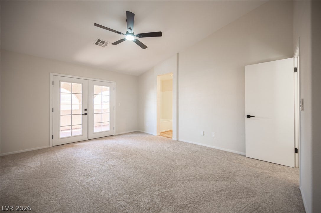 6133 Crystal Talon Street, Las Vegas, NV 89130 Plush carpeting and French doors highlight this vaulted Primary bedroom space.