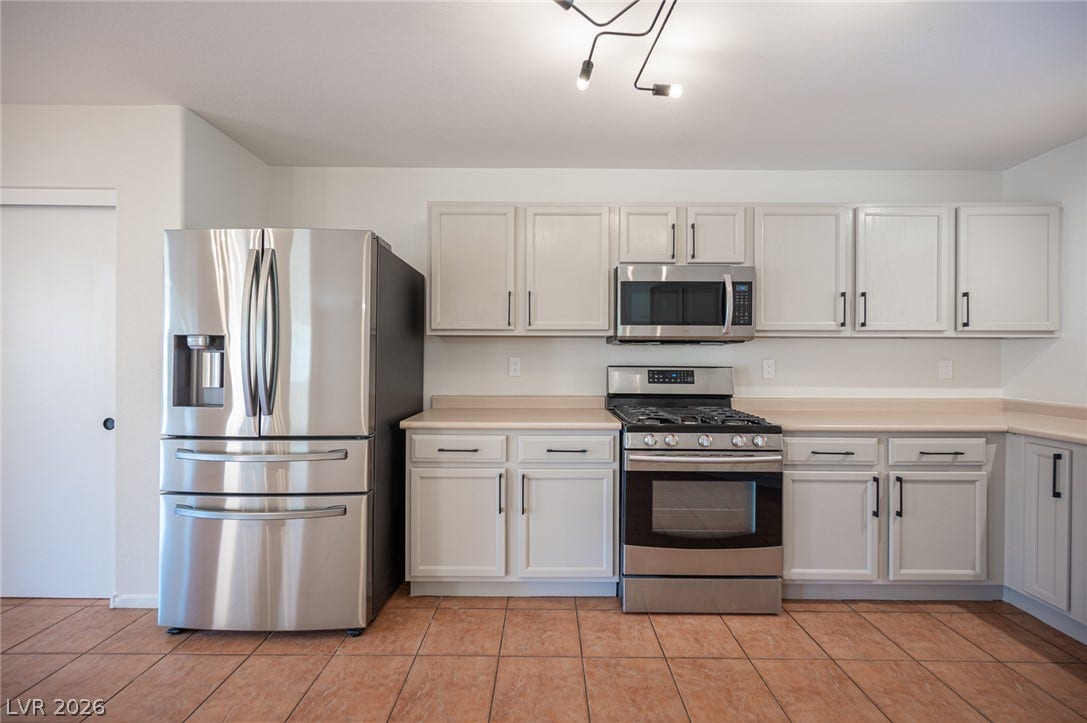 6133 Crystal Talon Street, Las Vegas, NV 89130 Stainless steel appliances complement clean cabinetry and tile flooring in this functional culinary space.