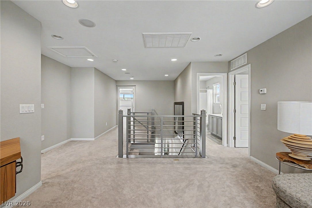 A spacious upper-level landing connects several rooms while overlooking the central staircase.