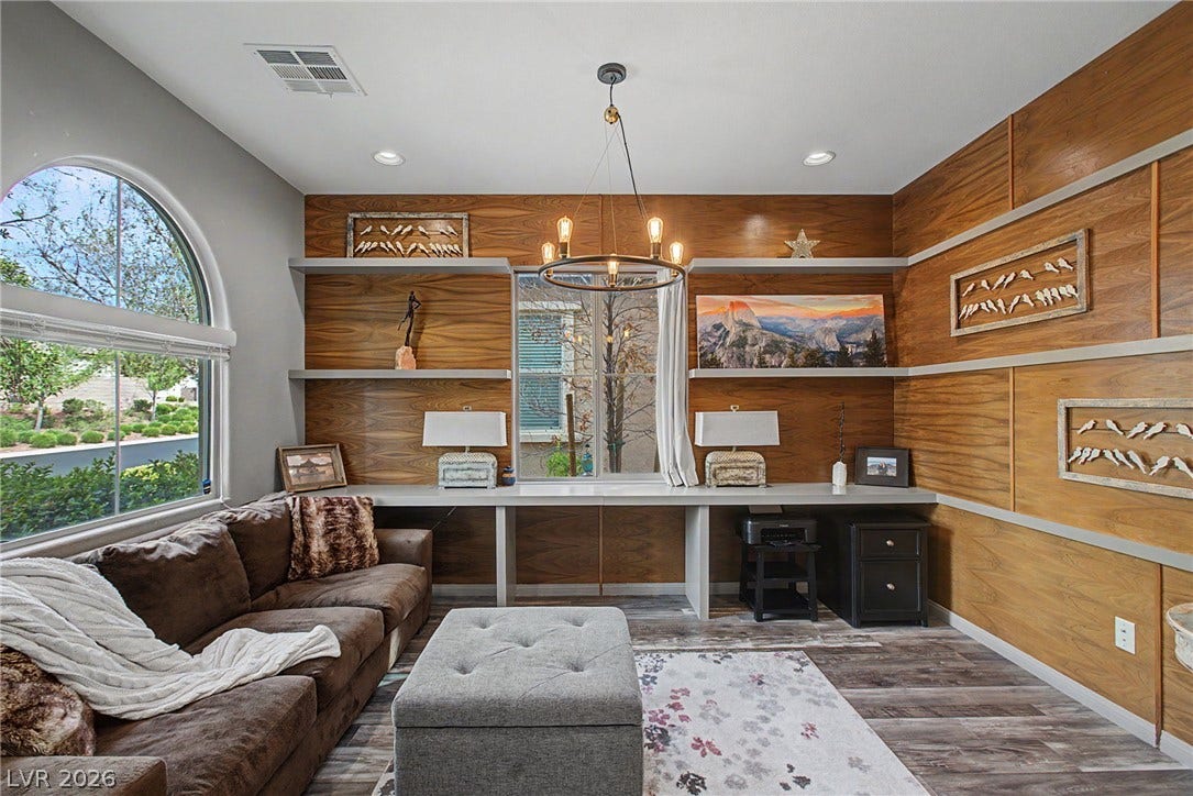 Rich wood-paneled walls and a built-in desk highlight this versatile home office.
