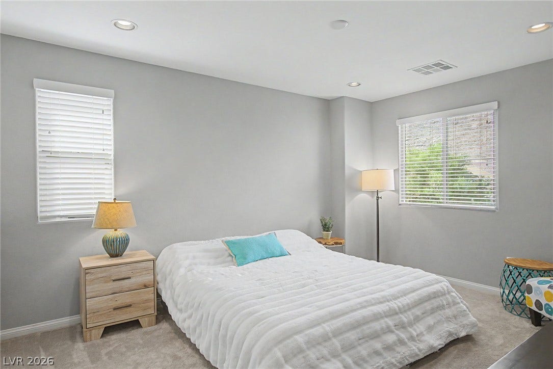 Recessed lighting illuminates this tranquil bedroom with soft carpeting and clean architectural lines.
