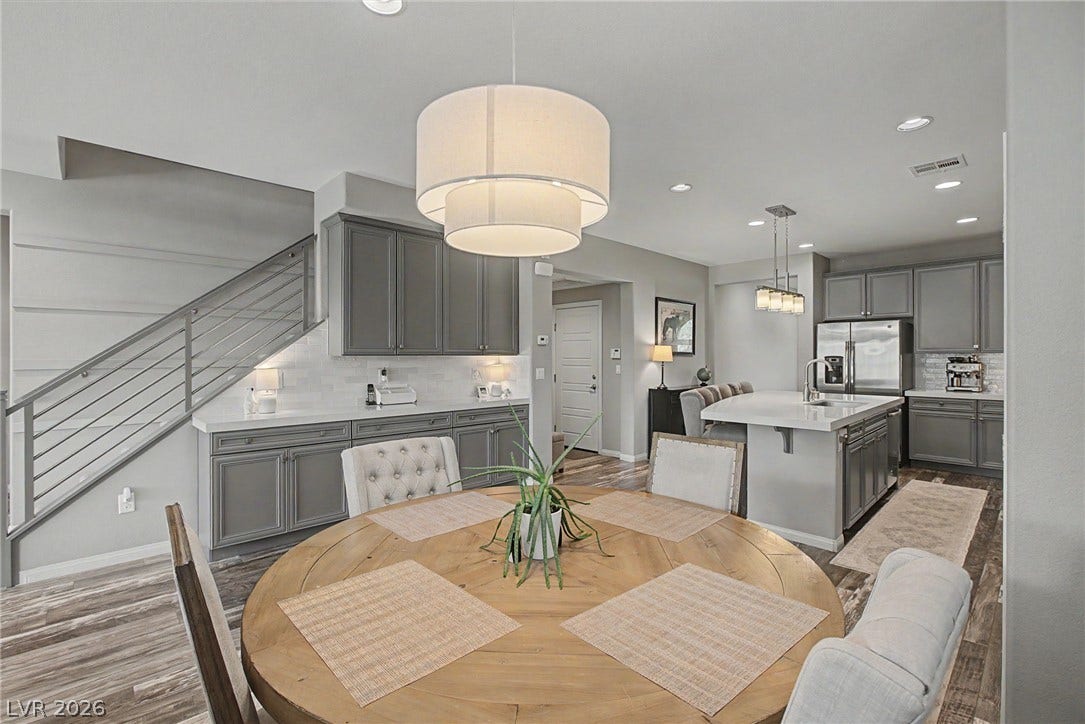Polished hard-surface flooring and recessed lighting connect this dining area to the open kitchen.