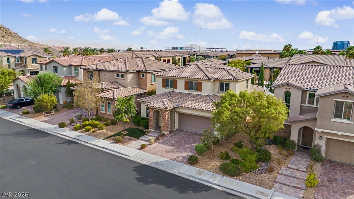 Spanish tile roofs and paved driveways define this desert neighborhood of multi-level residences.