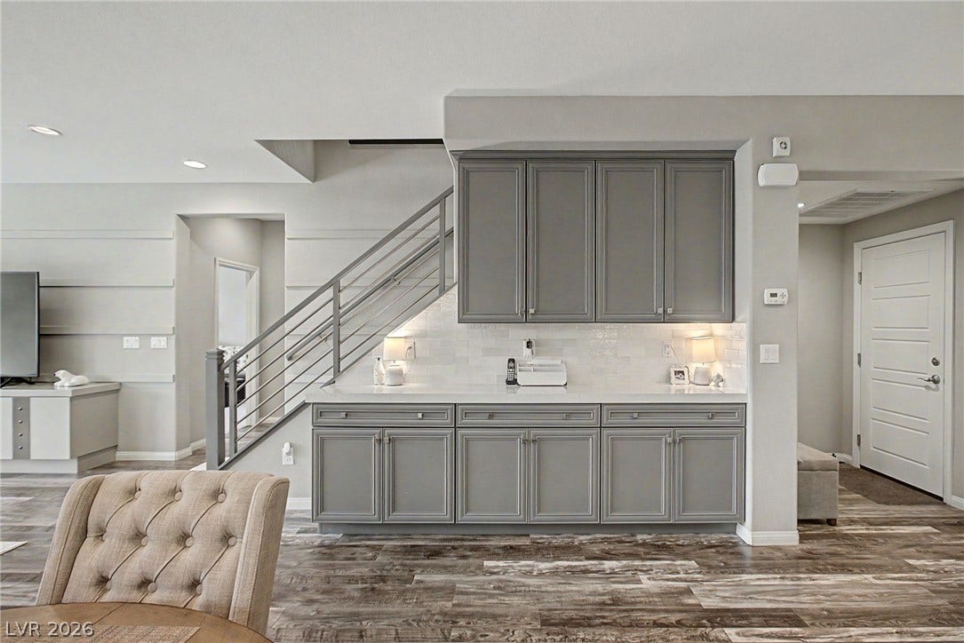Gleaming stone counters and custom built-in cabinetry complement the modern open staircase.