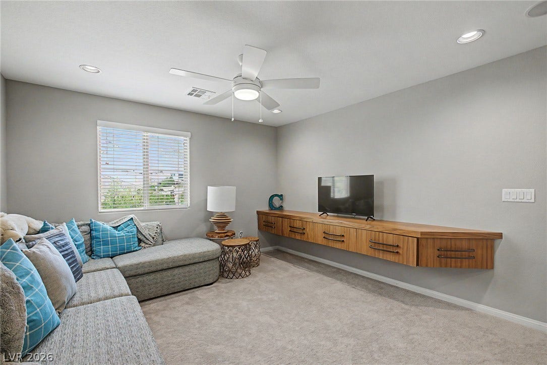 Recessed lighting and a floating wood console define this comfortable living space.