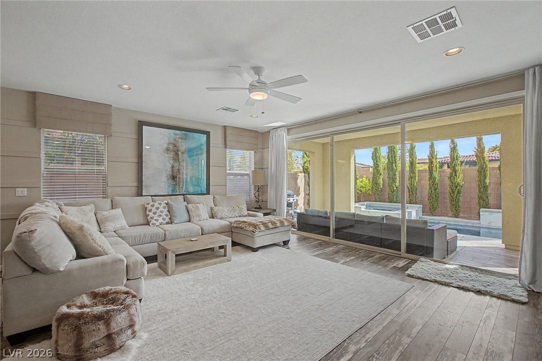 Sliding glass doors open directly to the outdoor living area from this wood-floored space.