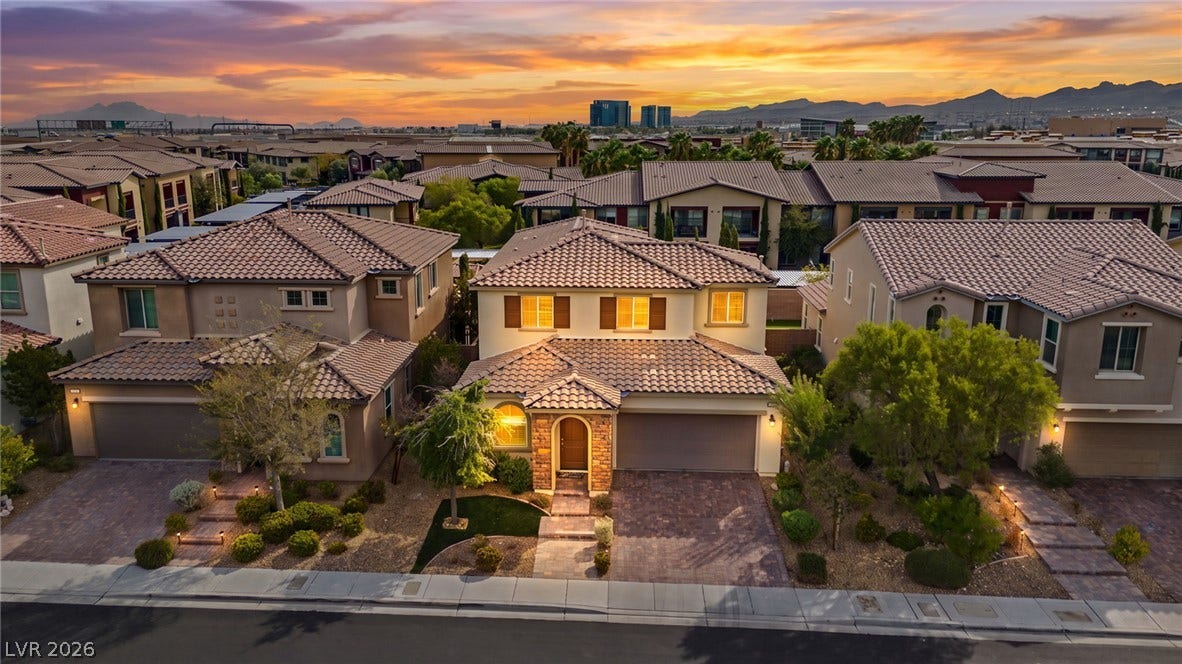 An attractive exterior facade is complemented by tile roofing and a paved driveway under vibrant skies.