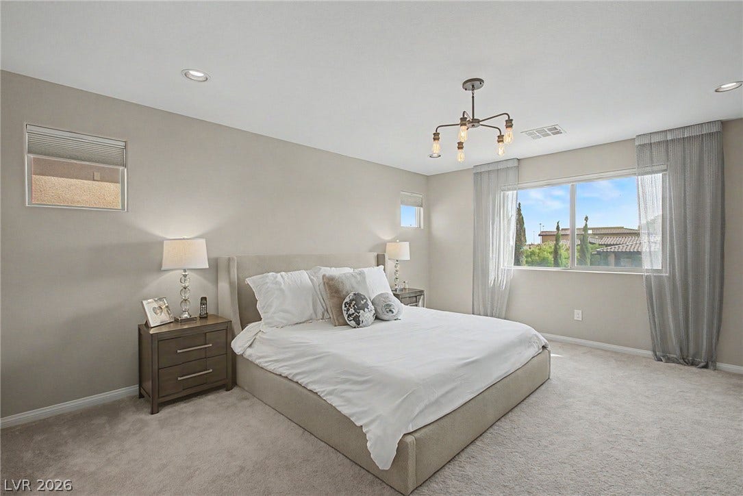 Plush carpeting and recessed lighting define this comfortable bedroom space.