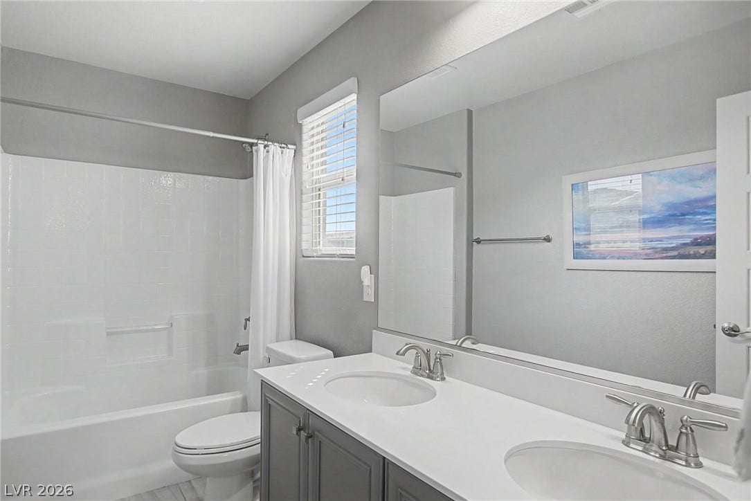 Double vanities and clean tile surrounds accent this contemporary bathroom.