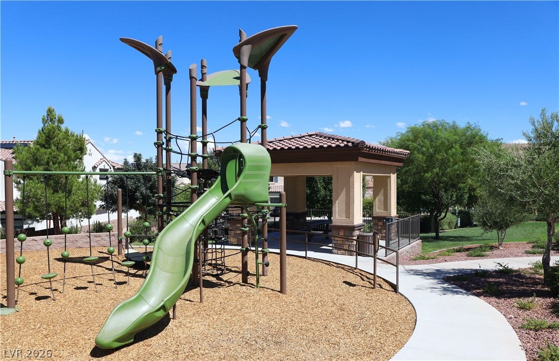 An inviting community park offers a modern playground structure alongside a shaded pavilion.