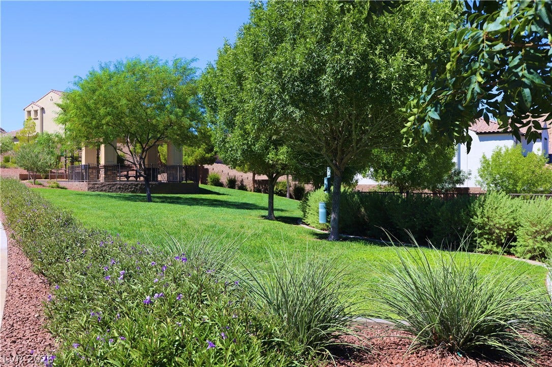 Lush grassy areas and mature shade trees surround a covered community gazebo.
